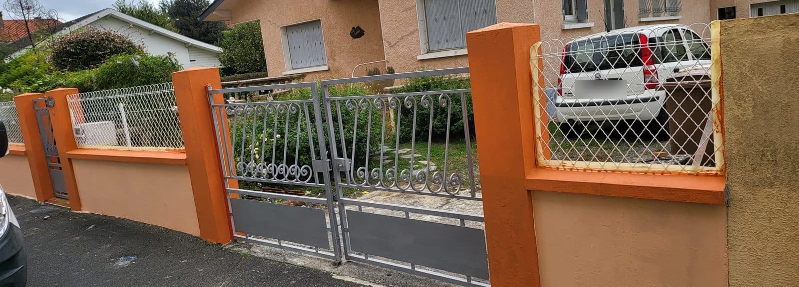 Portail gris et muret orange remis à neuf